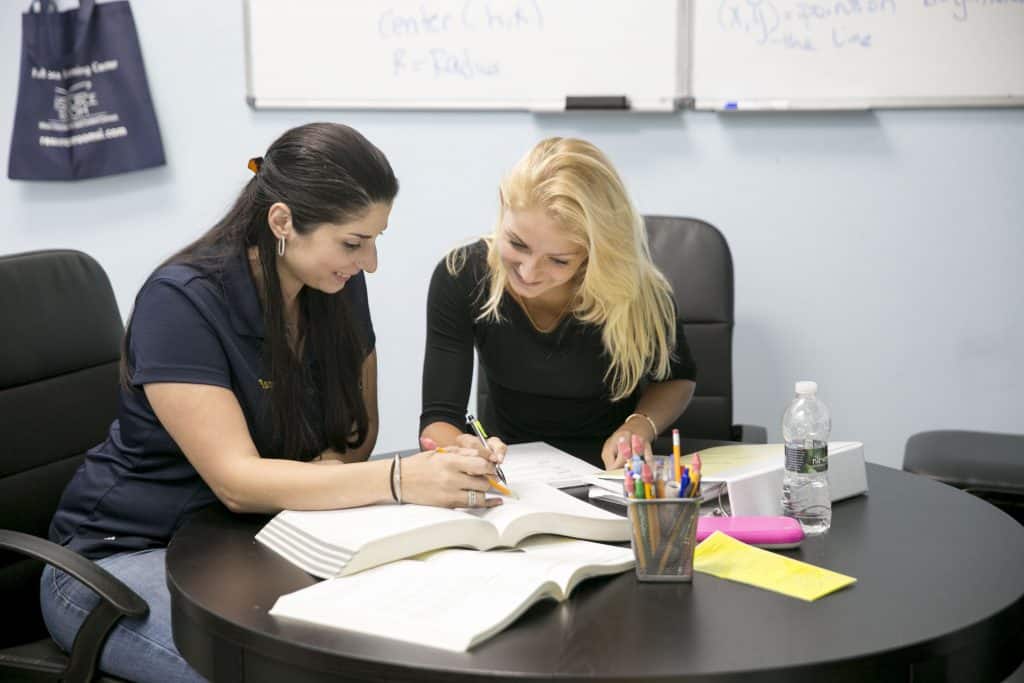 A tutor and student working through a problem together at a Resource Room table.